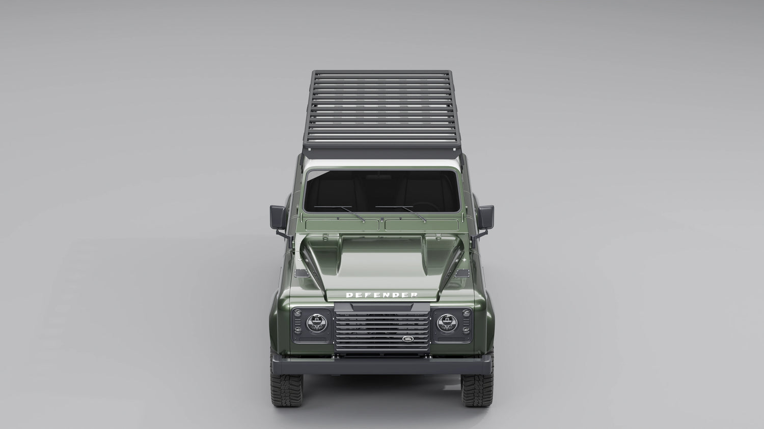 Direkte Frontansicht eines dunkelgrünen Land Rover Defender 110, die das flache, aerodynamische Profil des schwarzen Expeditions-Dachträgers zeigt.